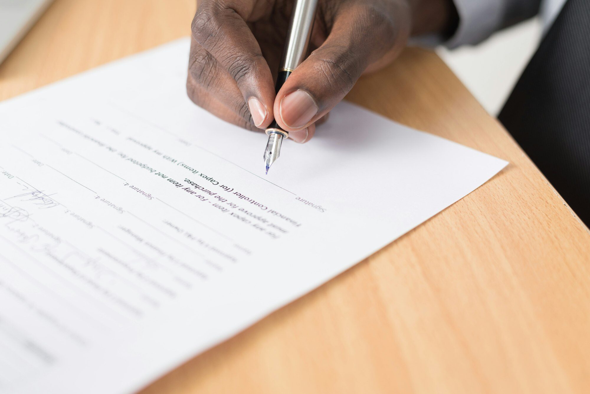 A document being signed with a fountain pen